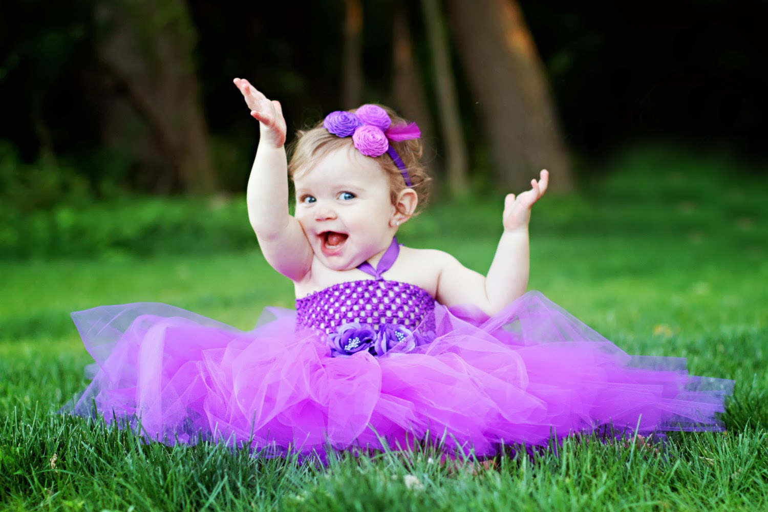 happy baby girl wearing a purple tutu